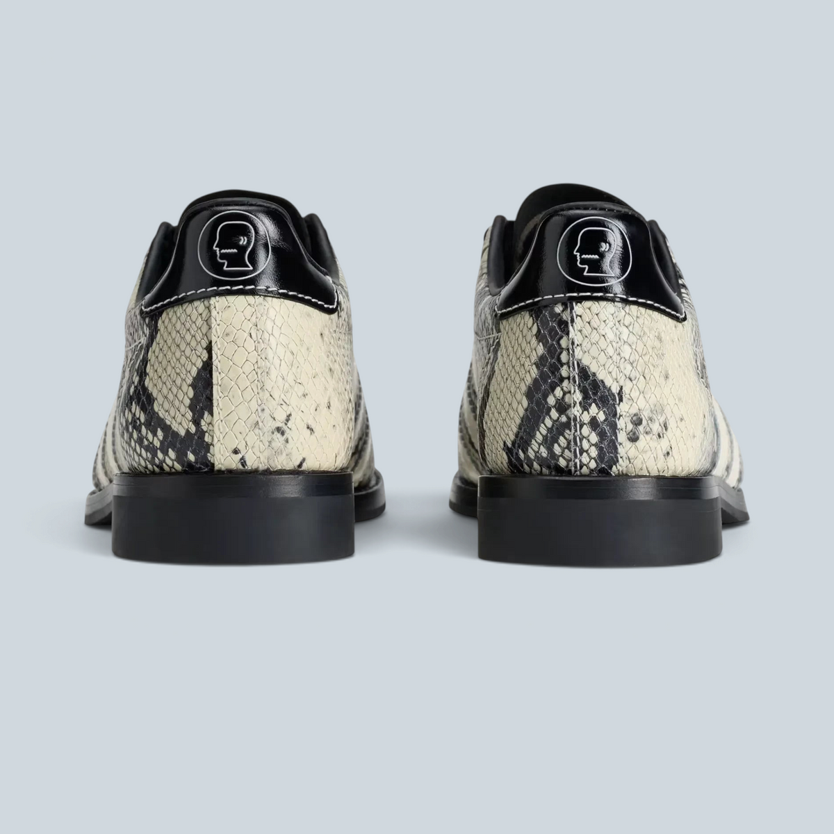 Vue arrière des baskets Saison adidas x Brain Dead en cuir effet serpent crème et noir avec logo au talon