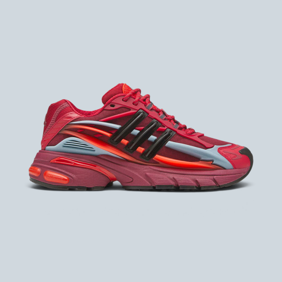 Baskets Saison Adidas Jellyfish rouges et noires, silhouette running rétro avec détails synthétiques et textiles.