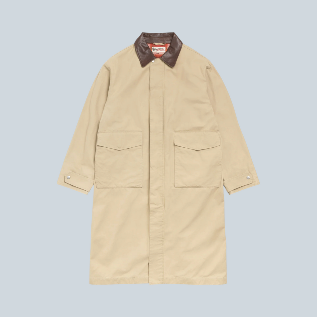 Manteau duster Stüssy couleur kaki en coton avec col contrastant marron, proposé par Saison