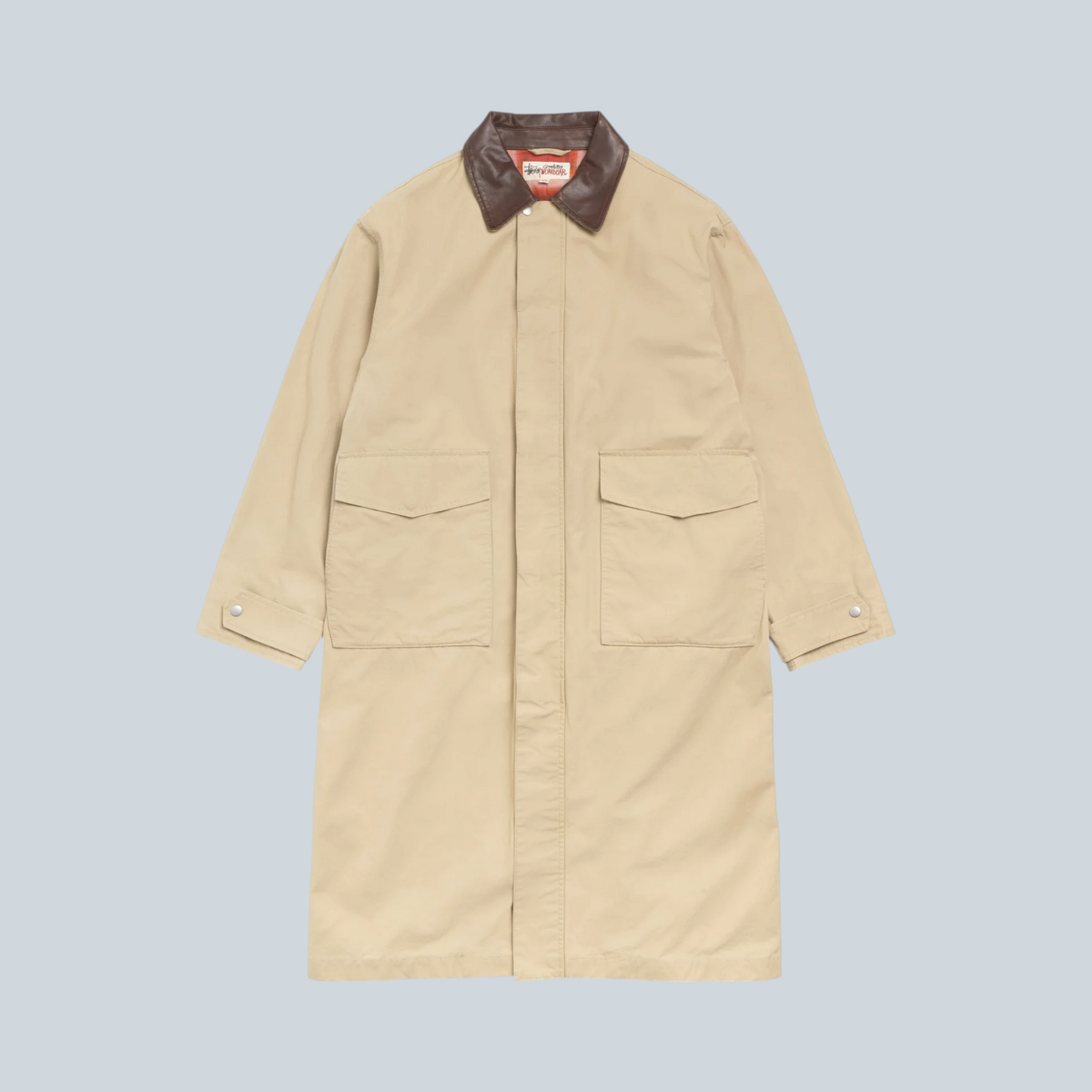 Manteau duster Stüssy couleur kaki en coton avec col contrastant marron, proposé par Saison
