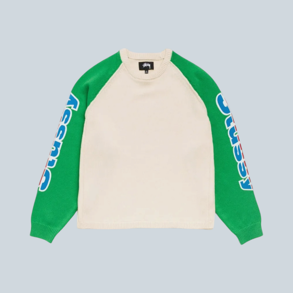 Pull raglan bicolore Saison Stüssy en laine mérinos et coton, corps naturel, manches vertes avec logo bleu