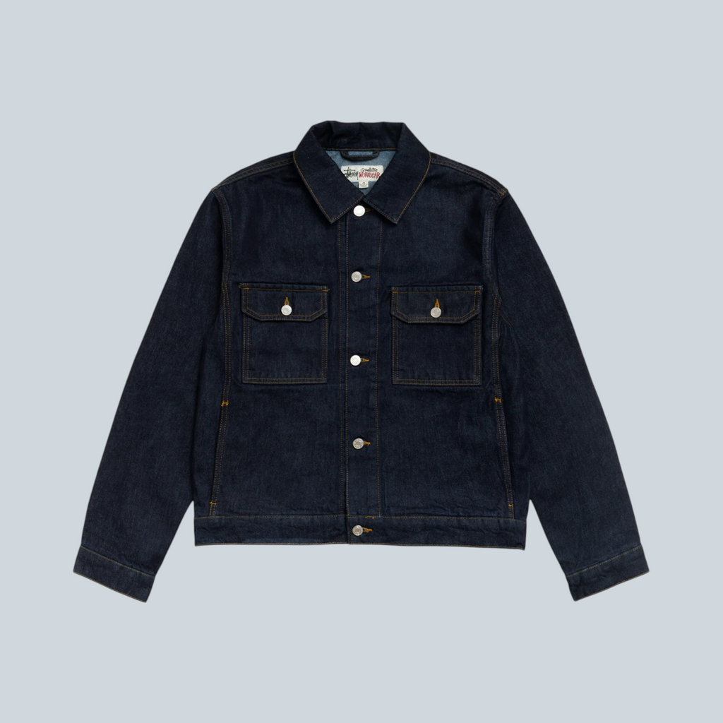 Veste trucker Stüssy en denim bleu indigo délavé avec poches poitrine et boutons métalliques, vendue par Saison