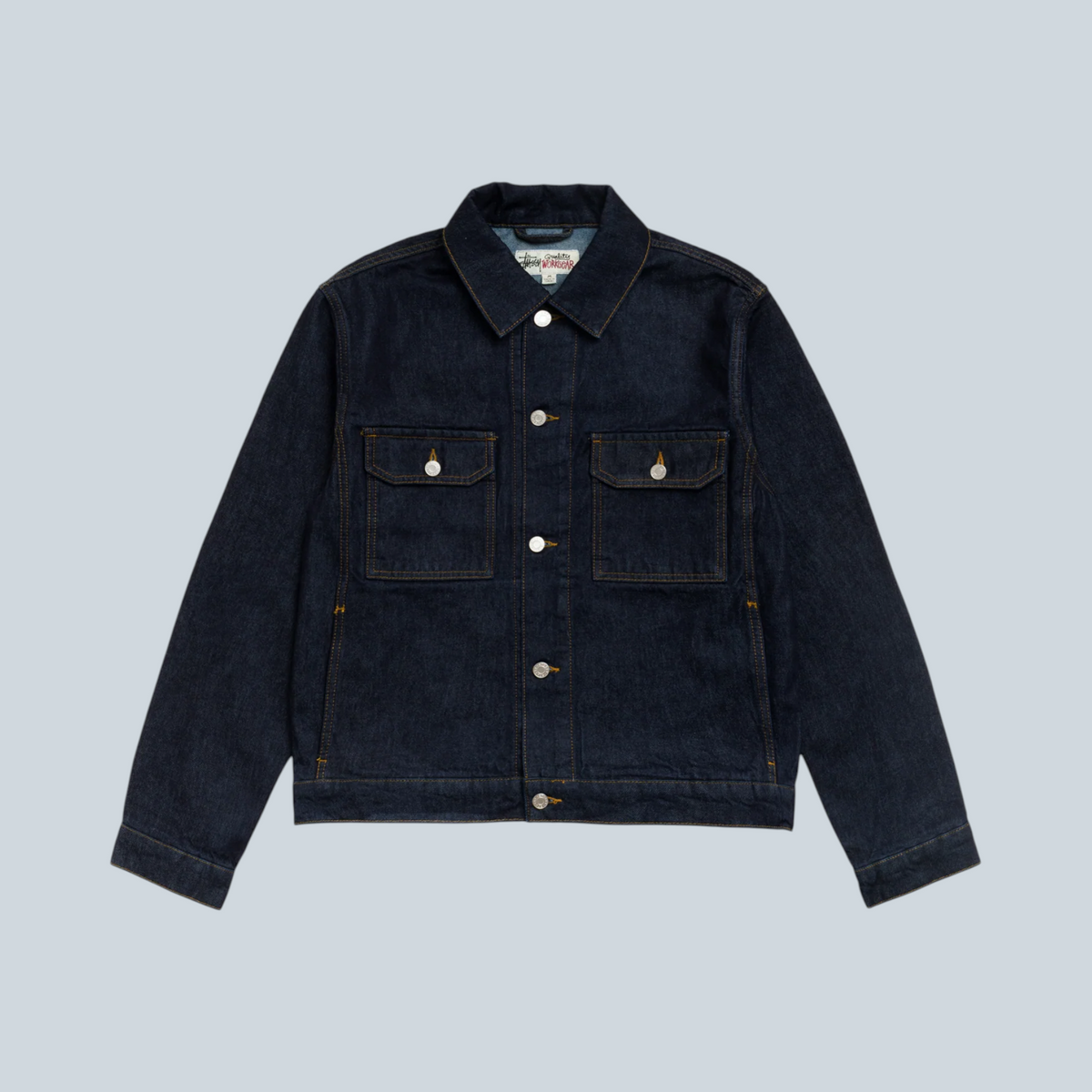 Veste trucker Stüssy en denim bleu indigo délavé avec poches poitrine et boutons métalliques, vendue par Saison